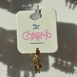 Gold boy charm on a 'little words project' tag with pink text