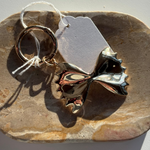 Farfalle bag charm keychain with a little words project tag and decorative element on a stone surface