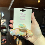 Hand holding a 'little words project' puffy heart charm hair clip with packaging