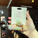 Hand holding a 'little words project' puffy heart charm hair clip with packaging