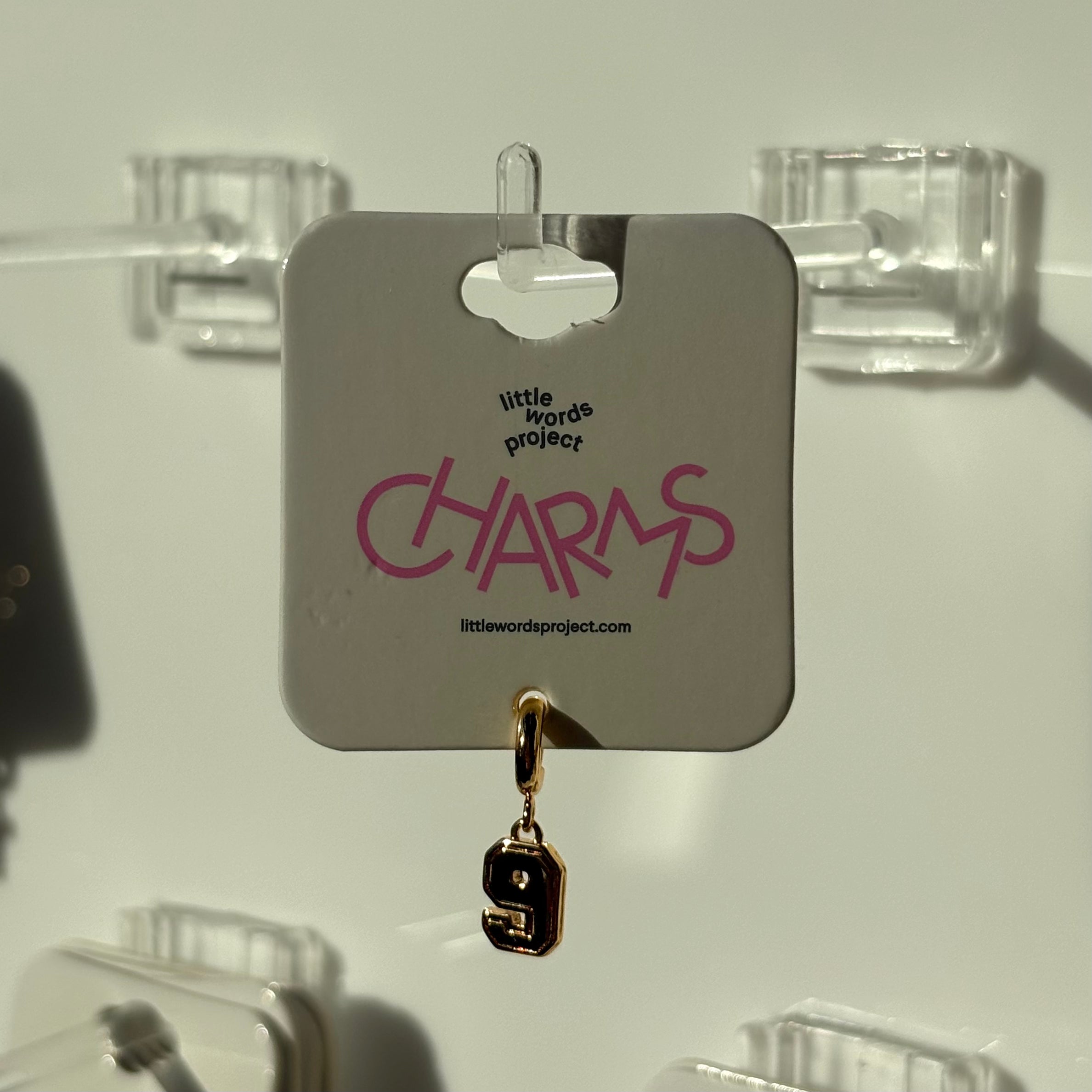 Gold 9 number charm on a display card with 'little words project' branding.