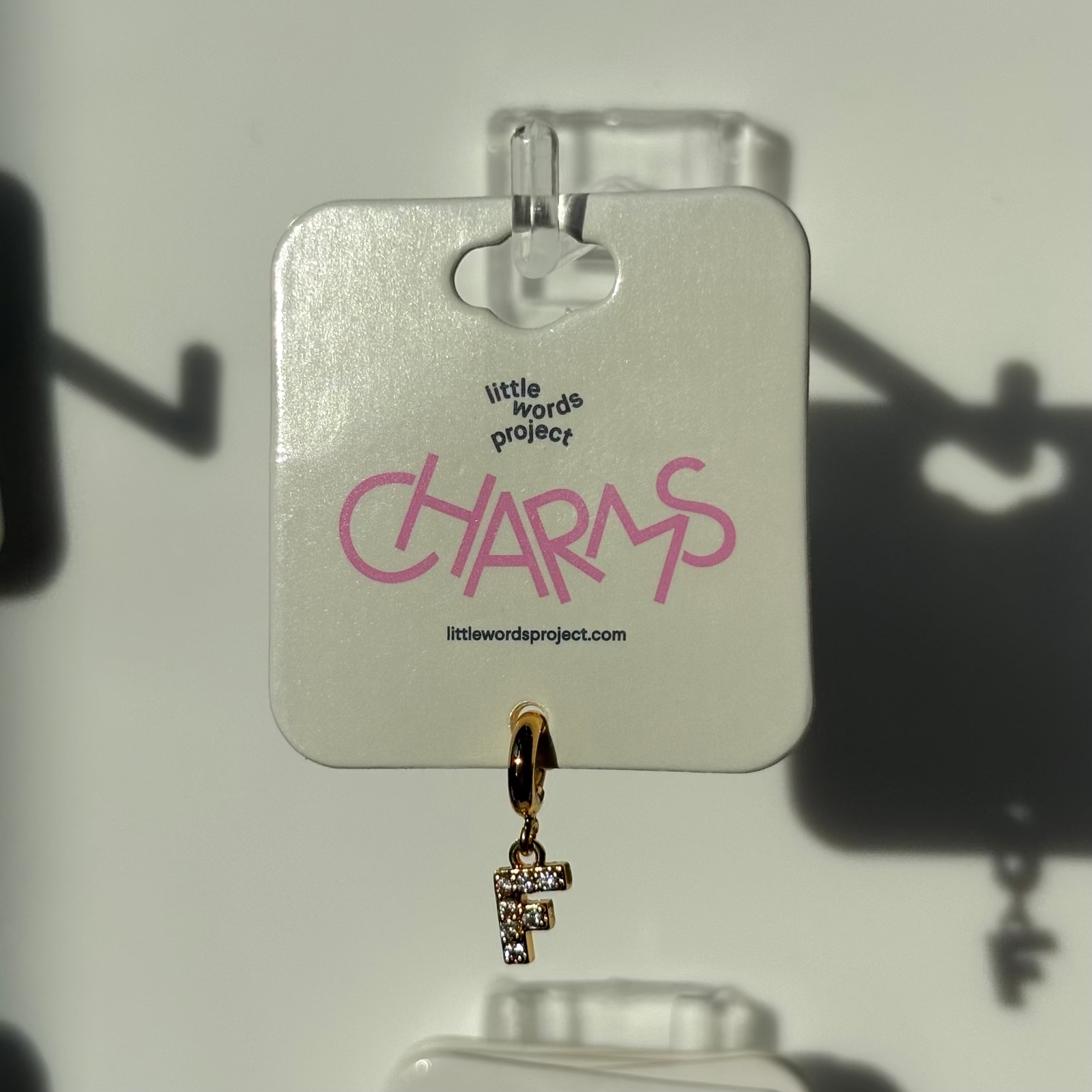 Gold F charm on a 'Little Words Project' card with a white background