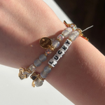 Little Words Project Bracelet with 'LUCKY' charm on a wrist against a neutral background