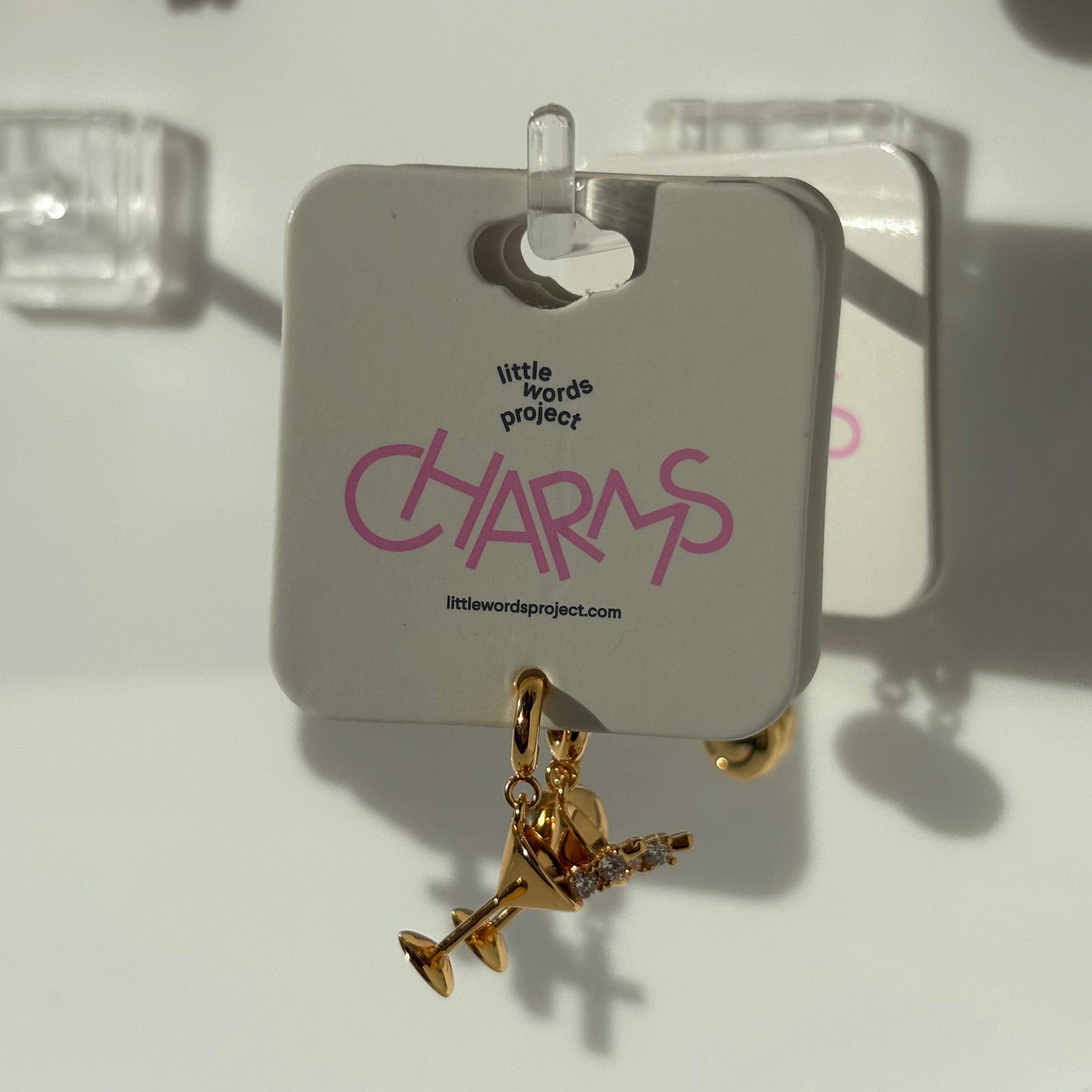 Gold martini charm on a 'Little Words Project' card with a white background
