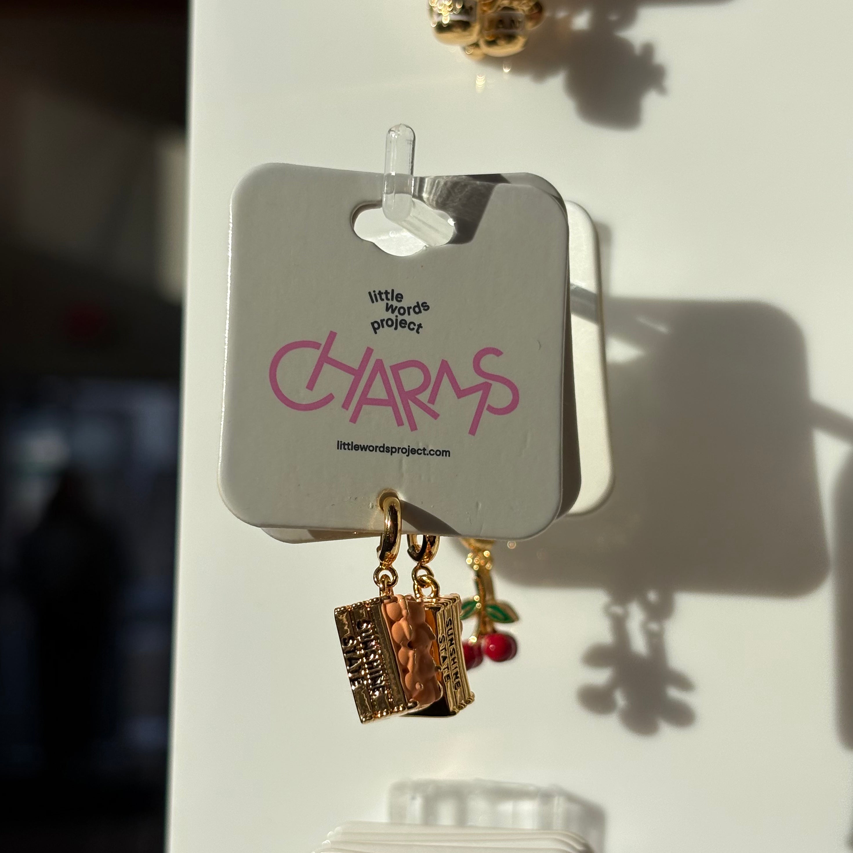 Set of orange crate charms on a card with 'little words project' branding