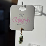 Green two peas charm on a 'Little Words Project' card with a blurred background