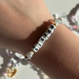 Little Words Project Bracelet with 'SISTER' beads on a wrist against a neutral background