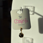 Black and gold soccer charm on a 'little words project' card with pink text.