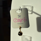 Black and gold soccer charm on a 'little words project' card with pink text.
