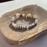 Little Words Project Bracelet with pearl beads and letter beads on a stone surface