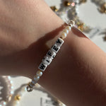 Little words project bracelet with 'WIFEY' beads on a wrist against a blurred background