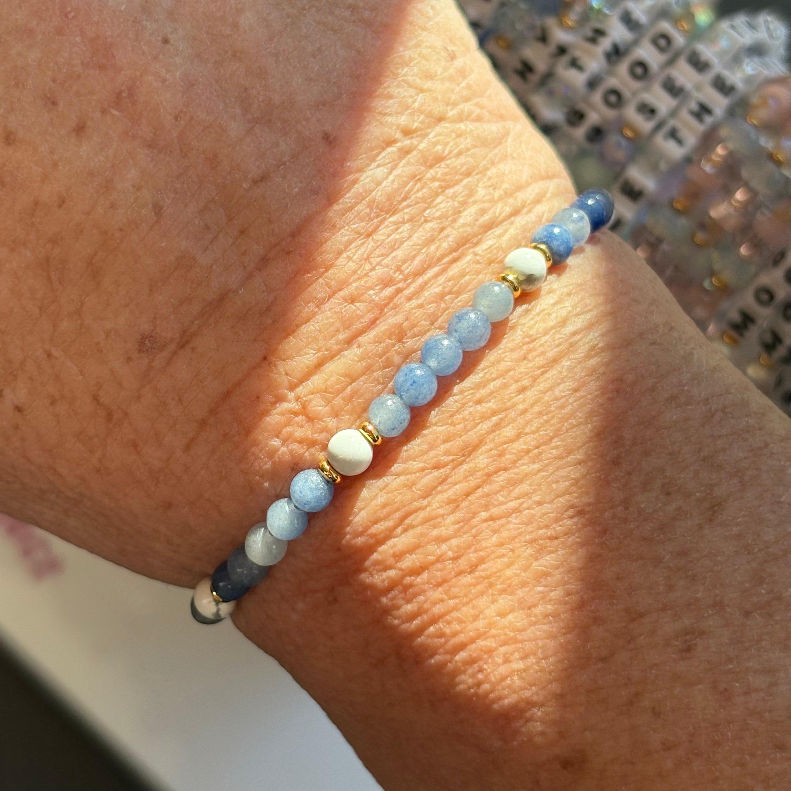 Close-up of a wrist wearing a blustone Little words project beaded bracelet