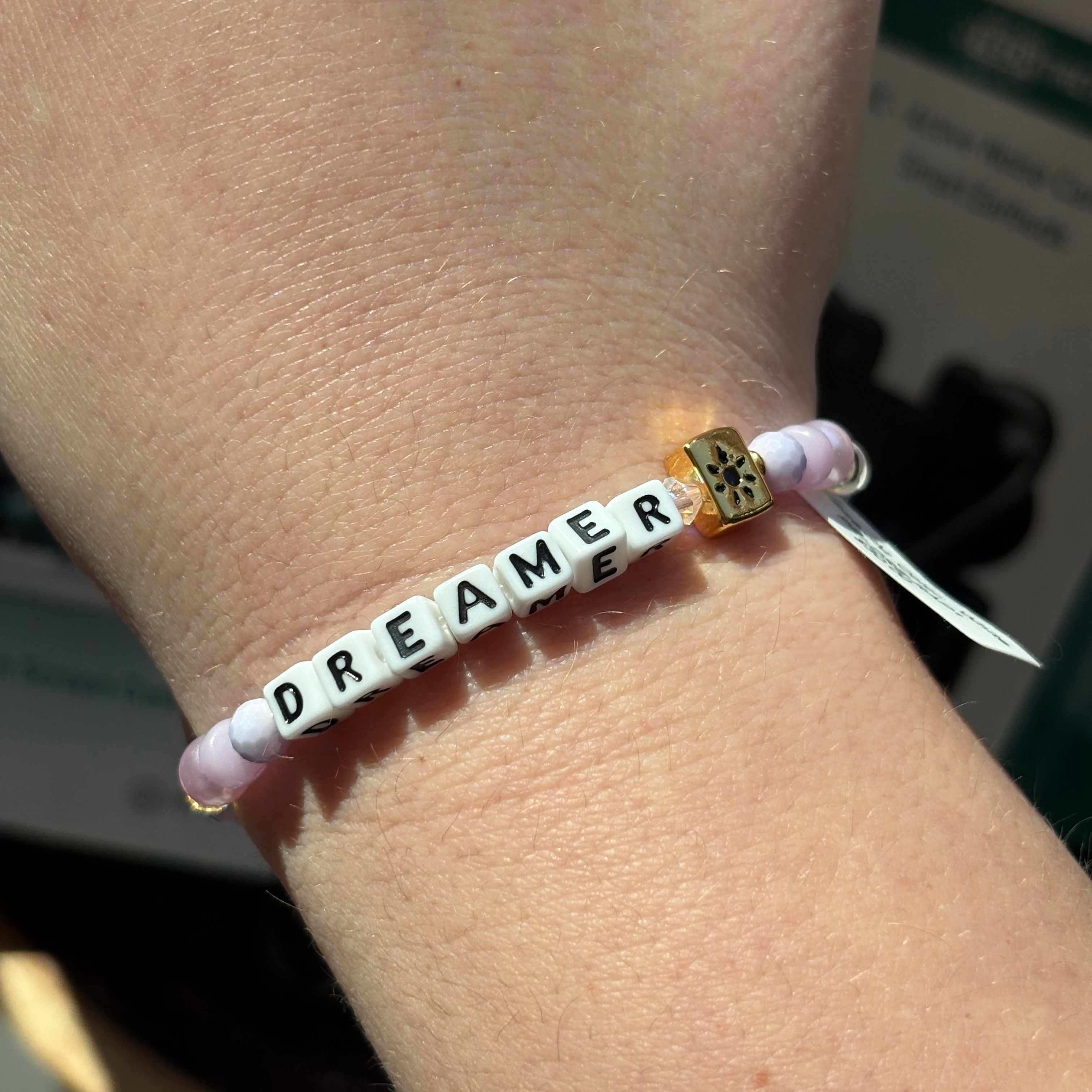 Bracelet with 'DREAMER' beads on a wrist