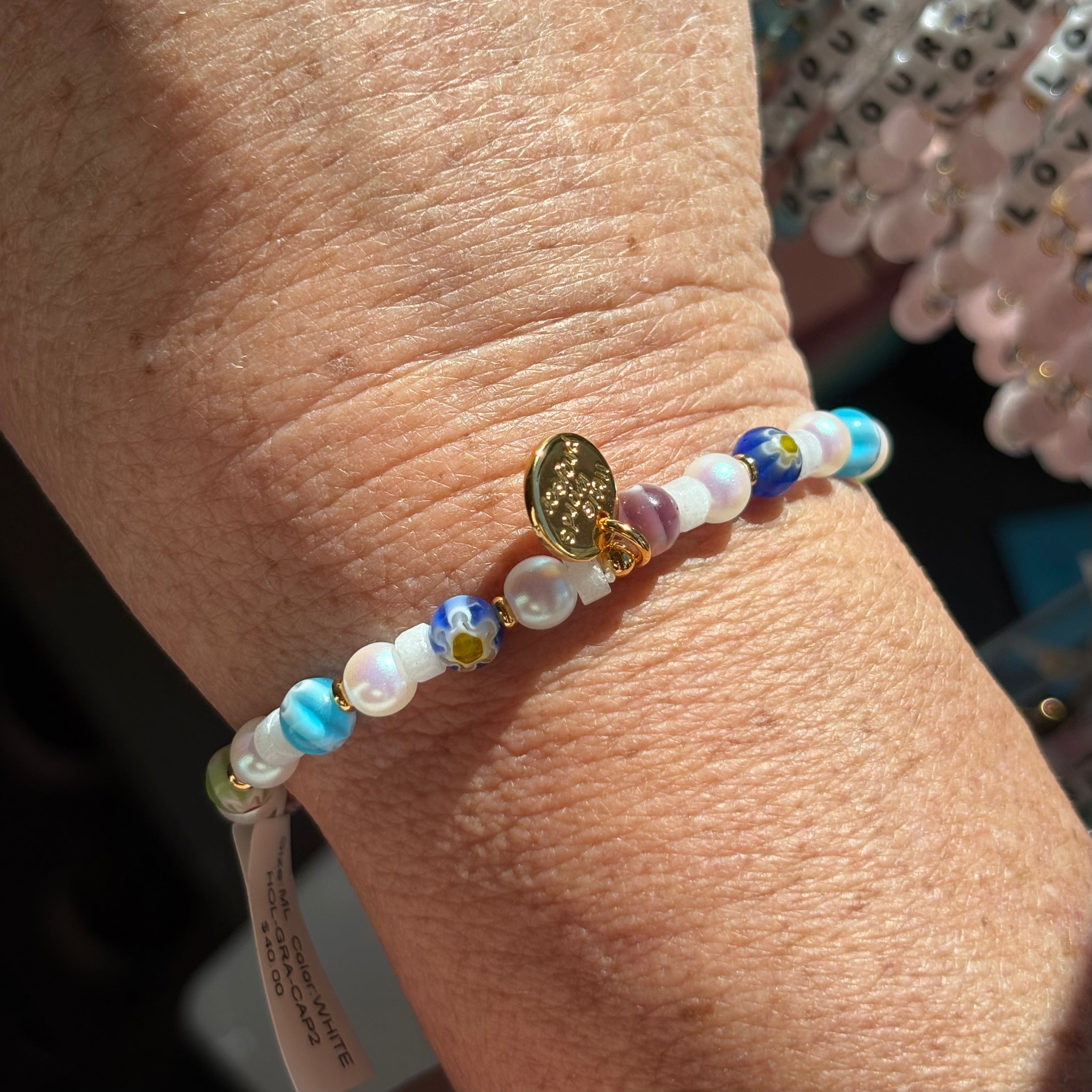 Multicolored backside picture of the beaded bracelet on a wrist with a blurred background