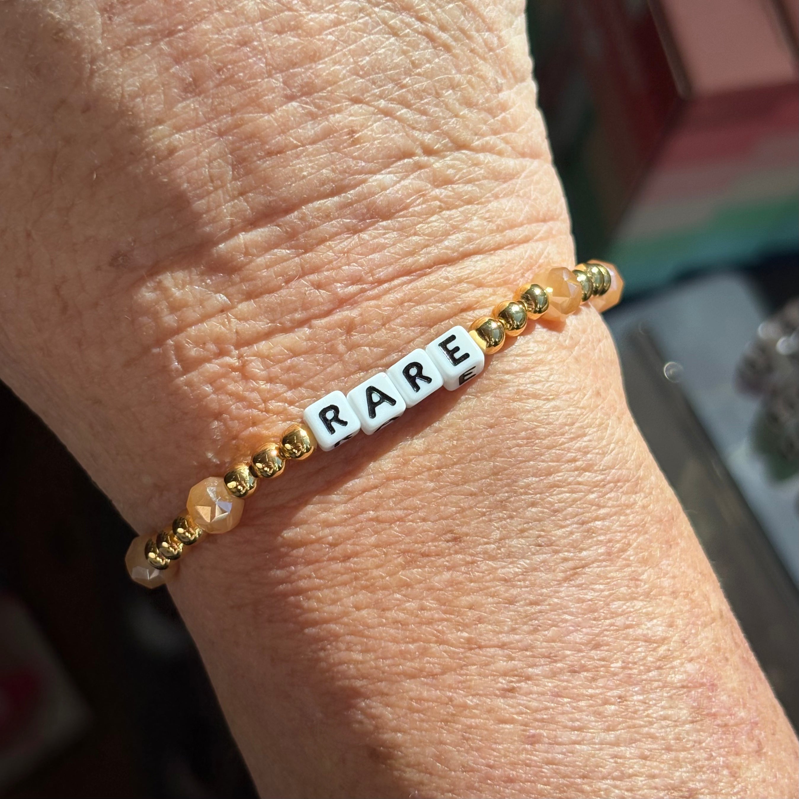 LWP bracelet with 'RARE' beads on a wrist