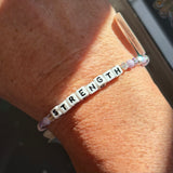 LWP bracelet with 'STRENGTH' beads on a wrist
