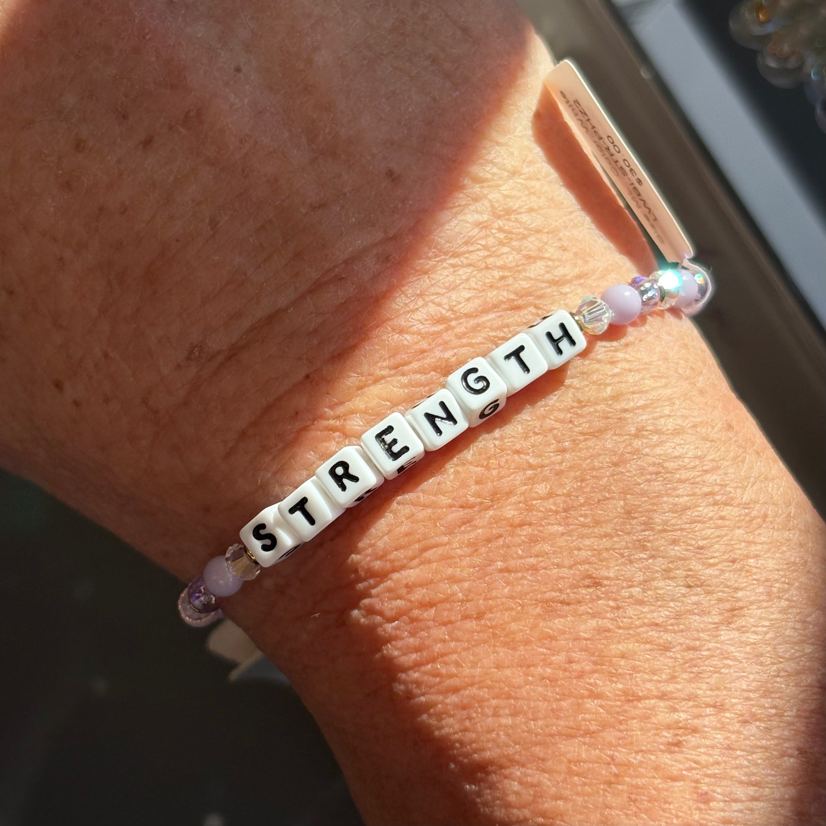 LWP bracelet with 'STRENGTH' beads on a wrist