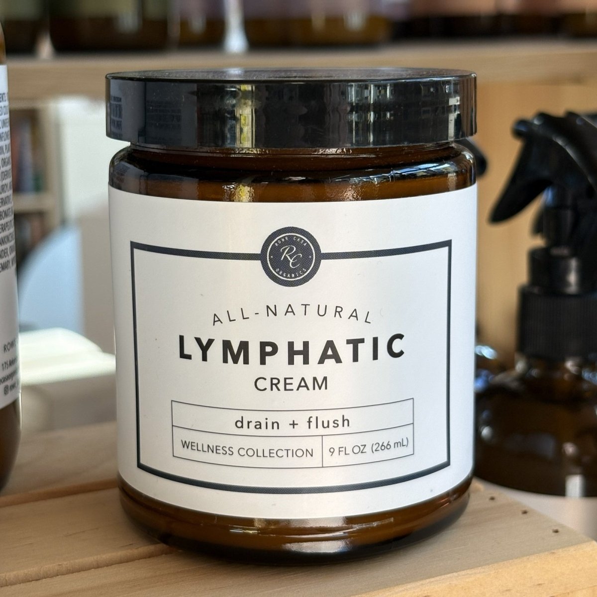 Jar of Rowe Casa all-natural lymphatic cream on a wooden surface