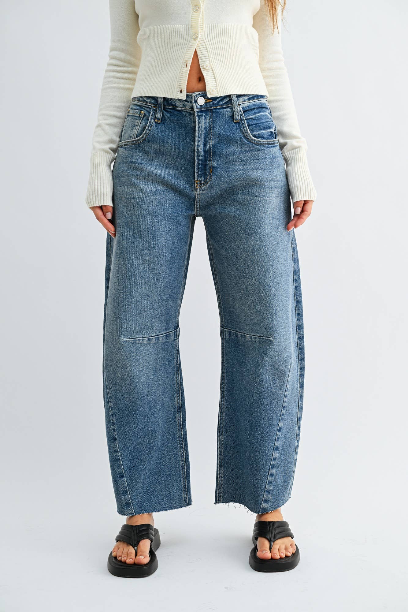 Medium wash barrel jeans with seam detailing and a raw hem