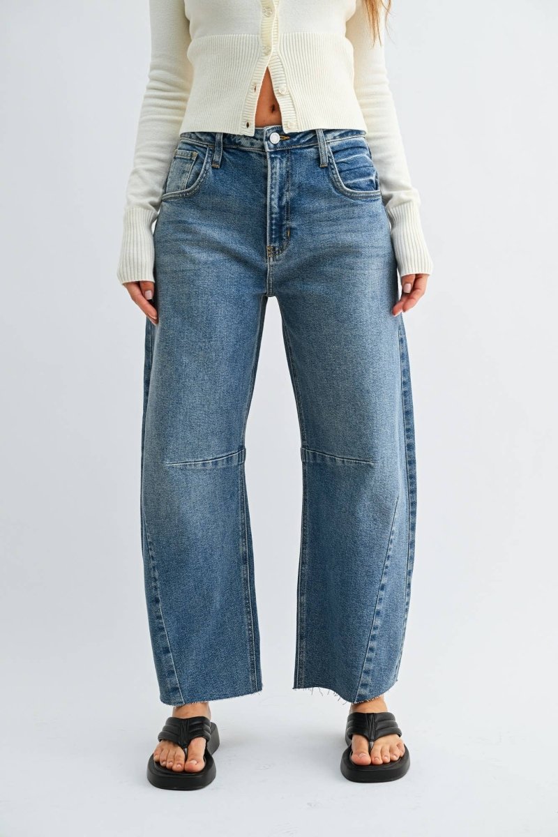 Medium wash barrel jeans with seam detailing and a raw hem