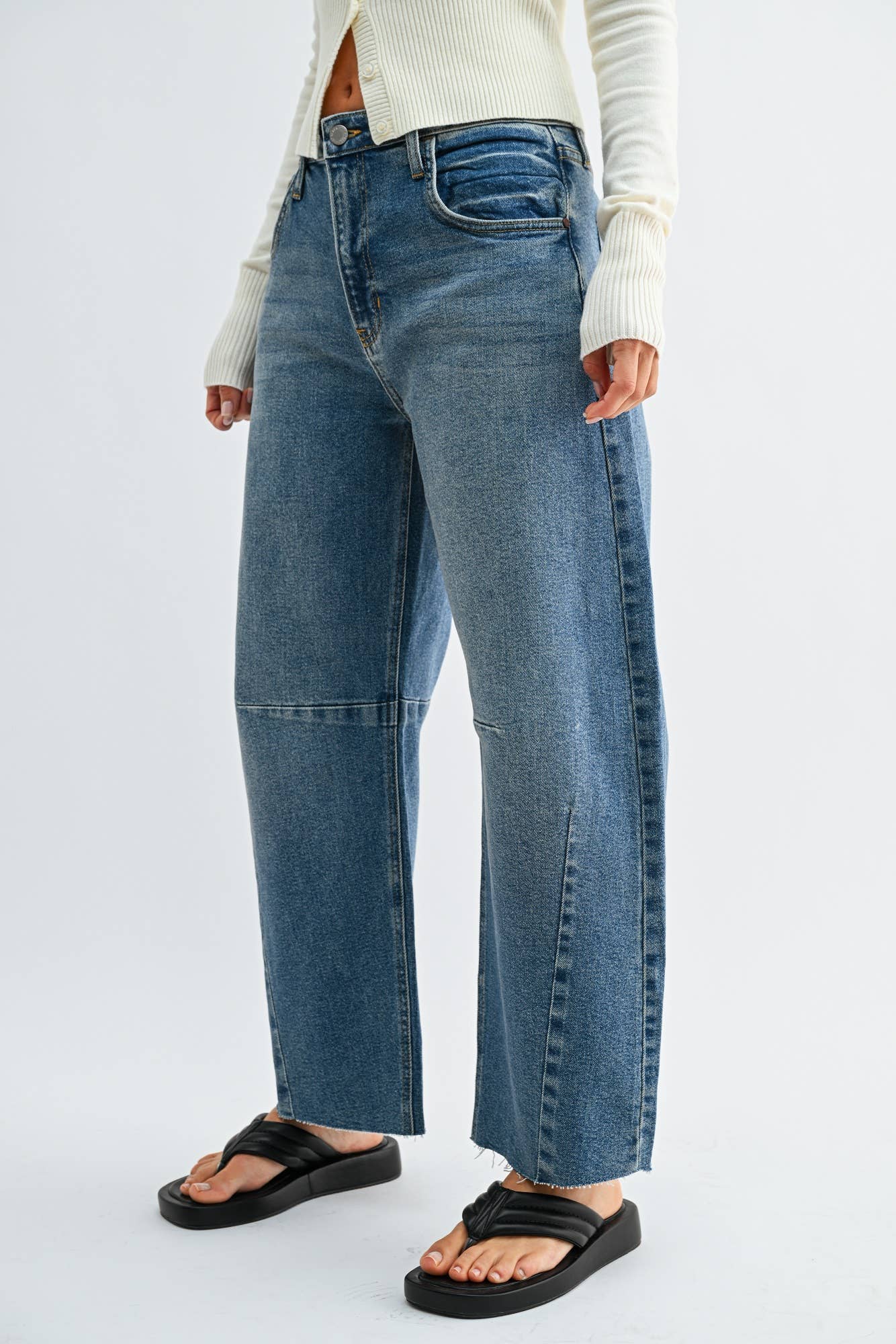 Medium wash barrel jeans with seam detailing and a raw hem