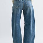 Medium wash barrel jeans with seam detailing and a raw hem