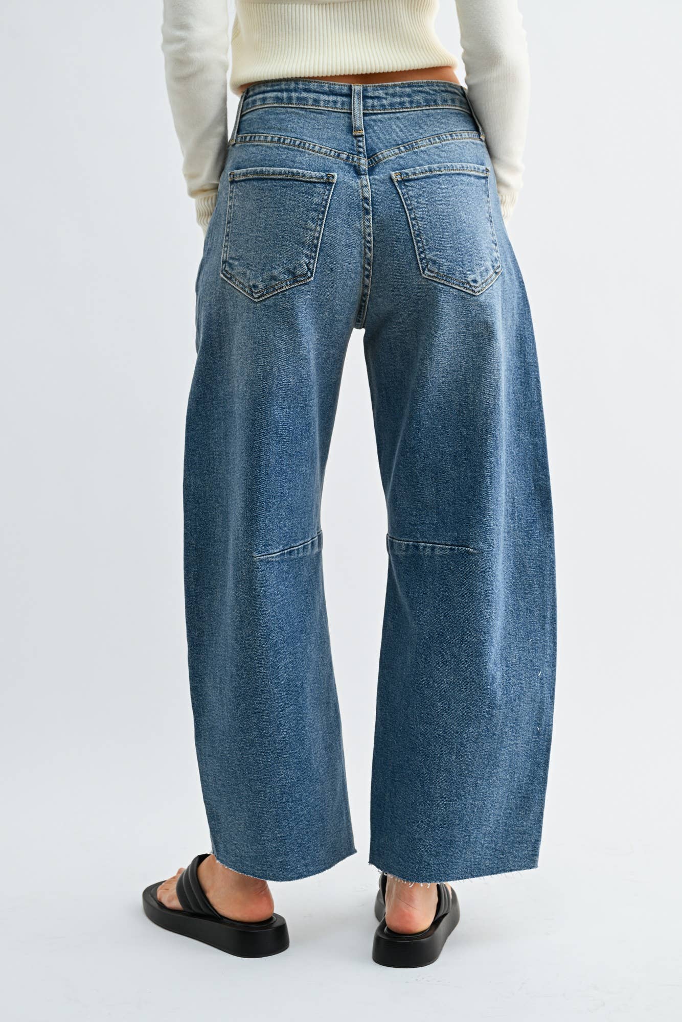 Medium wash barrel jeans with seam detailing and a raw hem