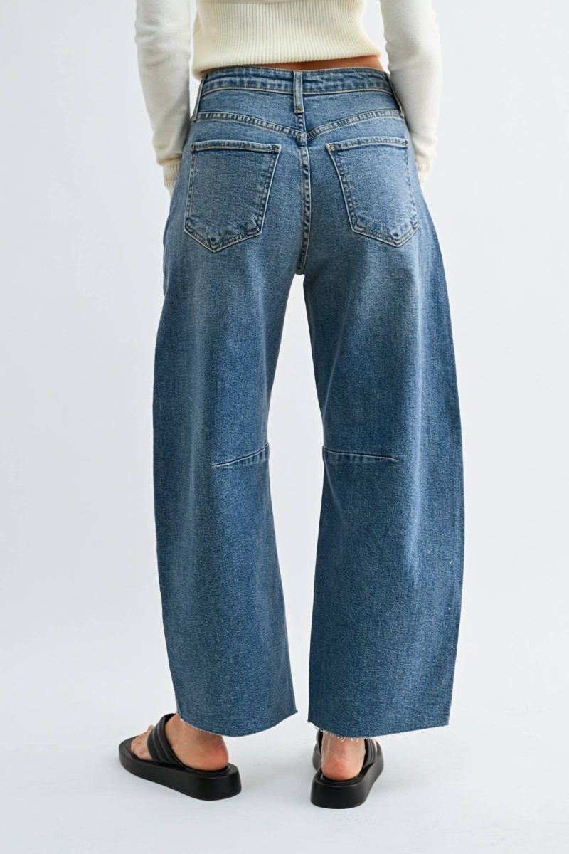 Medium wash barrel jeans with seam detailing and a raw hem