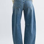 Medium wash barrel jeans with seam detailing and a raw hem