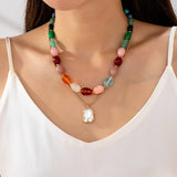 Multi-color stone and crystal pendant necklace in green, pink, and burgundy