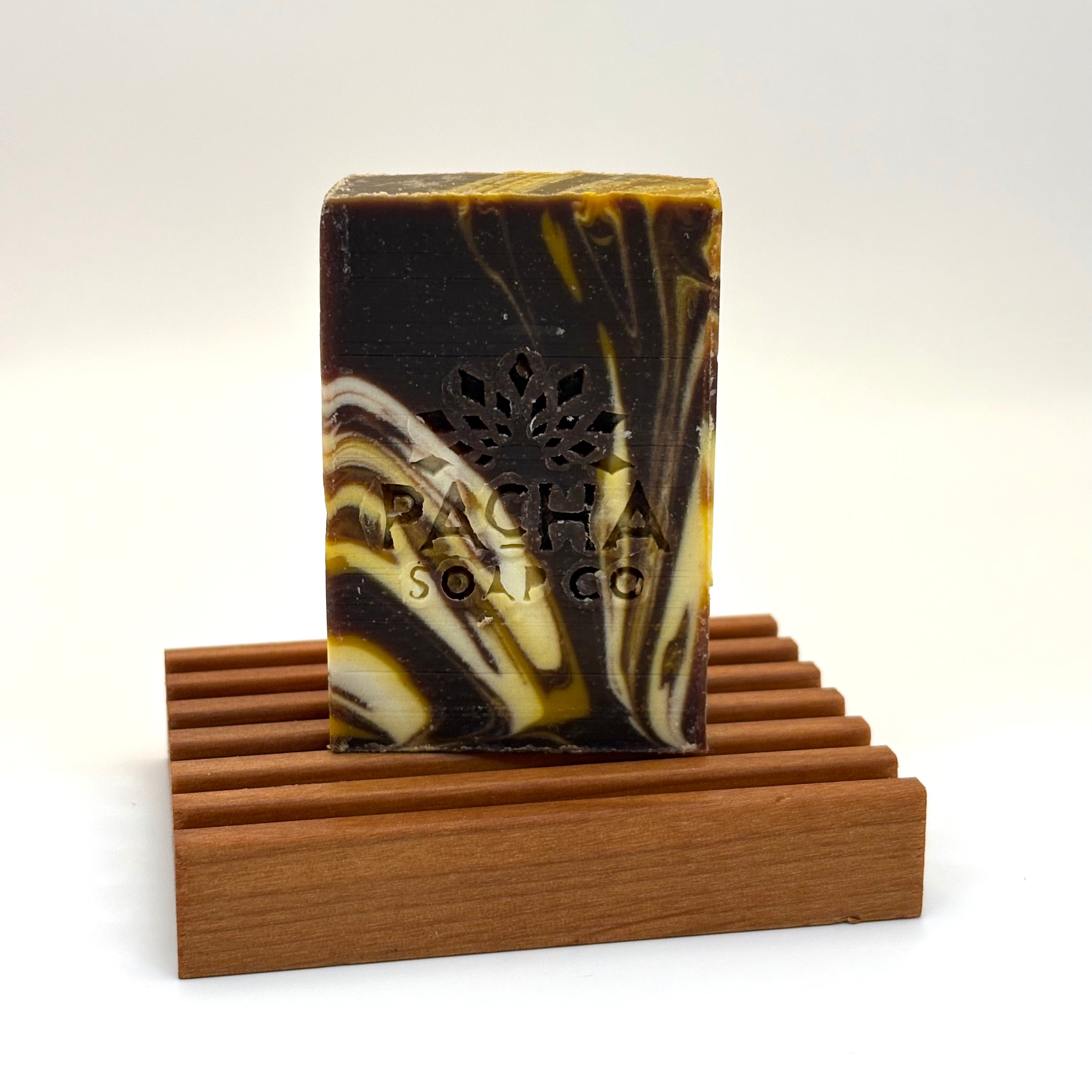 Marbled soap bar on a wooden stand with 'Pacha Soap Co' branding.