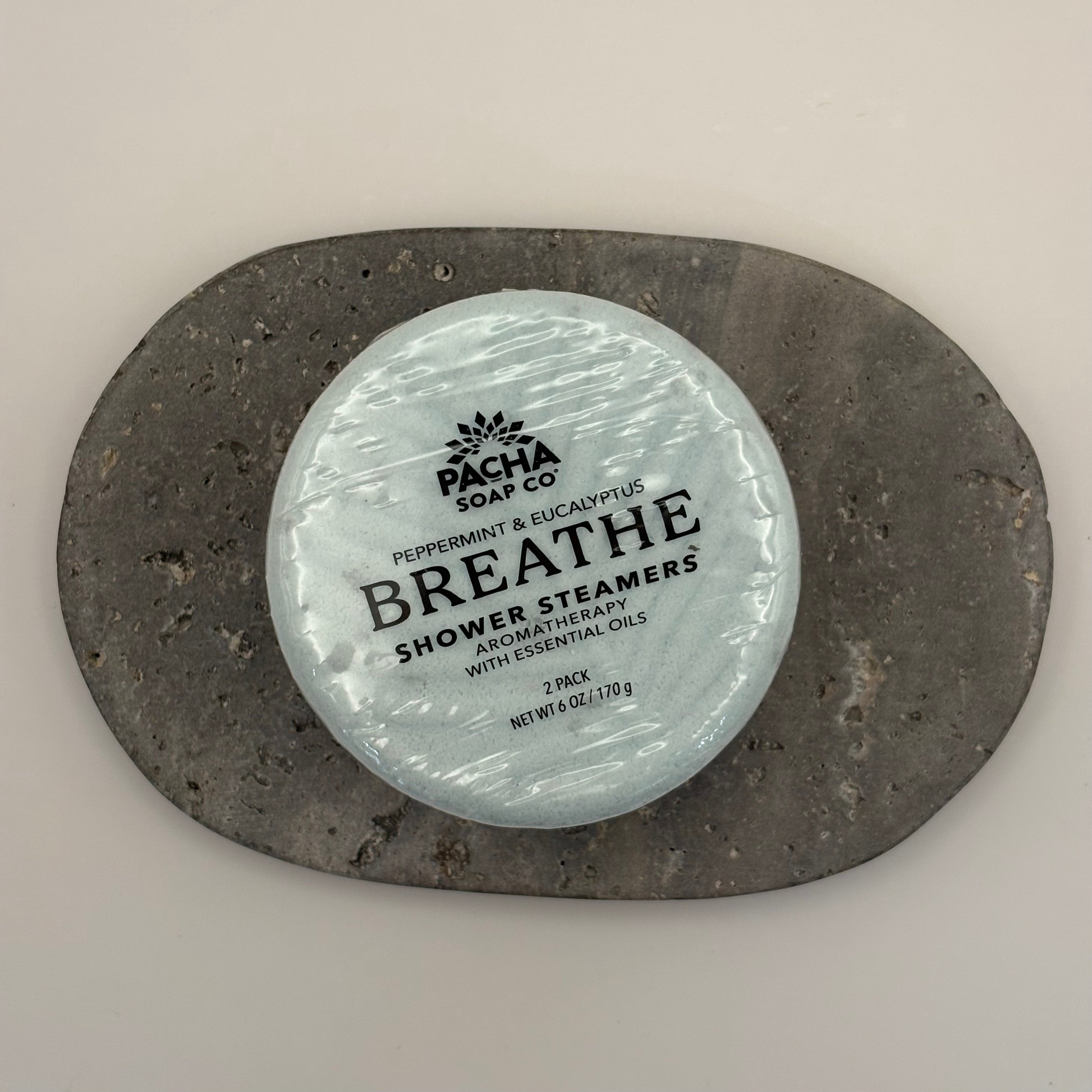 Pacha Soap Co. Breathe shower steamers packaging on a stone surface