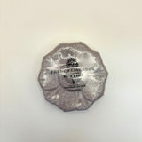 French Lavender bath bomb wrapped in silver foil on a light beige background