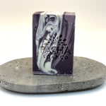 Marbled french lavender purple and white soap bar on a gray stone surface with 'Pacha Soap Co' branding.
