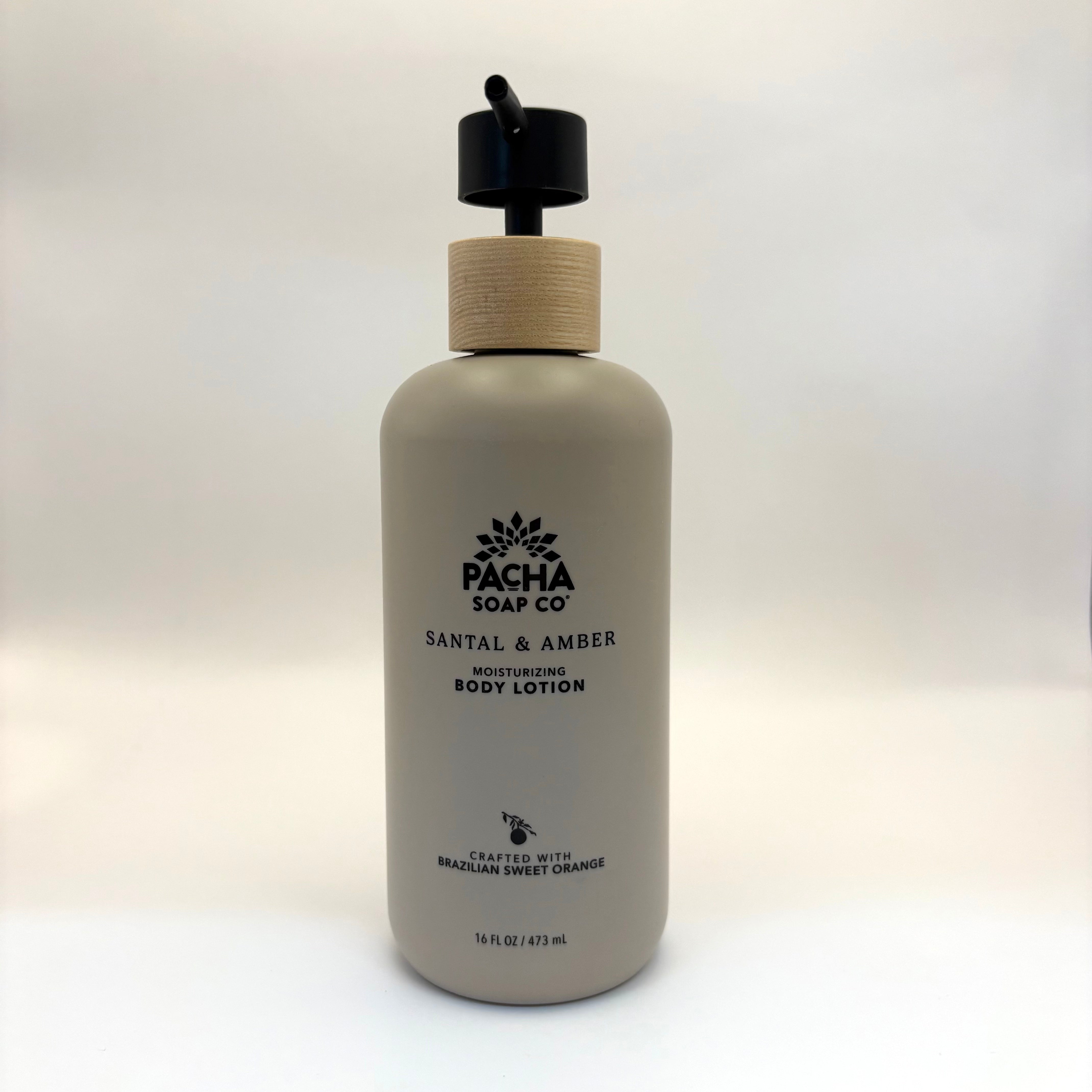 Santal and amber body lotion bottle with wooden cap on a white background