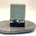 Bar of vanilla and sage soap with 'Pacha Soap Co' logo on a stone surface