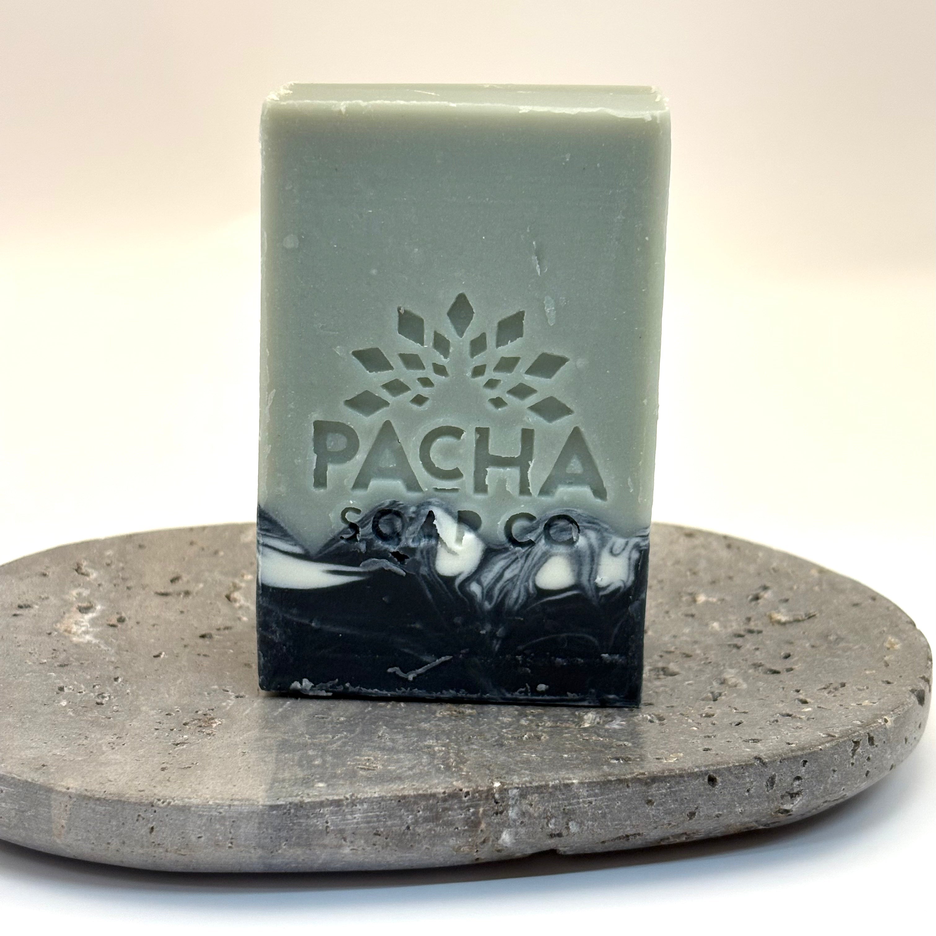 Bar of vanilla and sage soap with 'Pacha Soap Co' logo on a stone surface