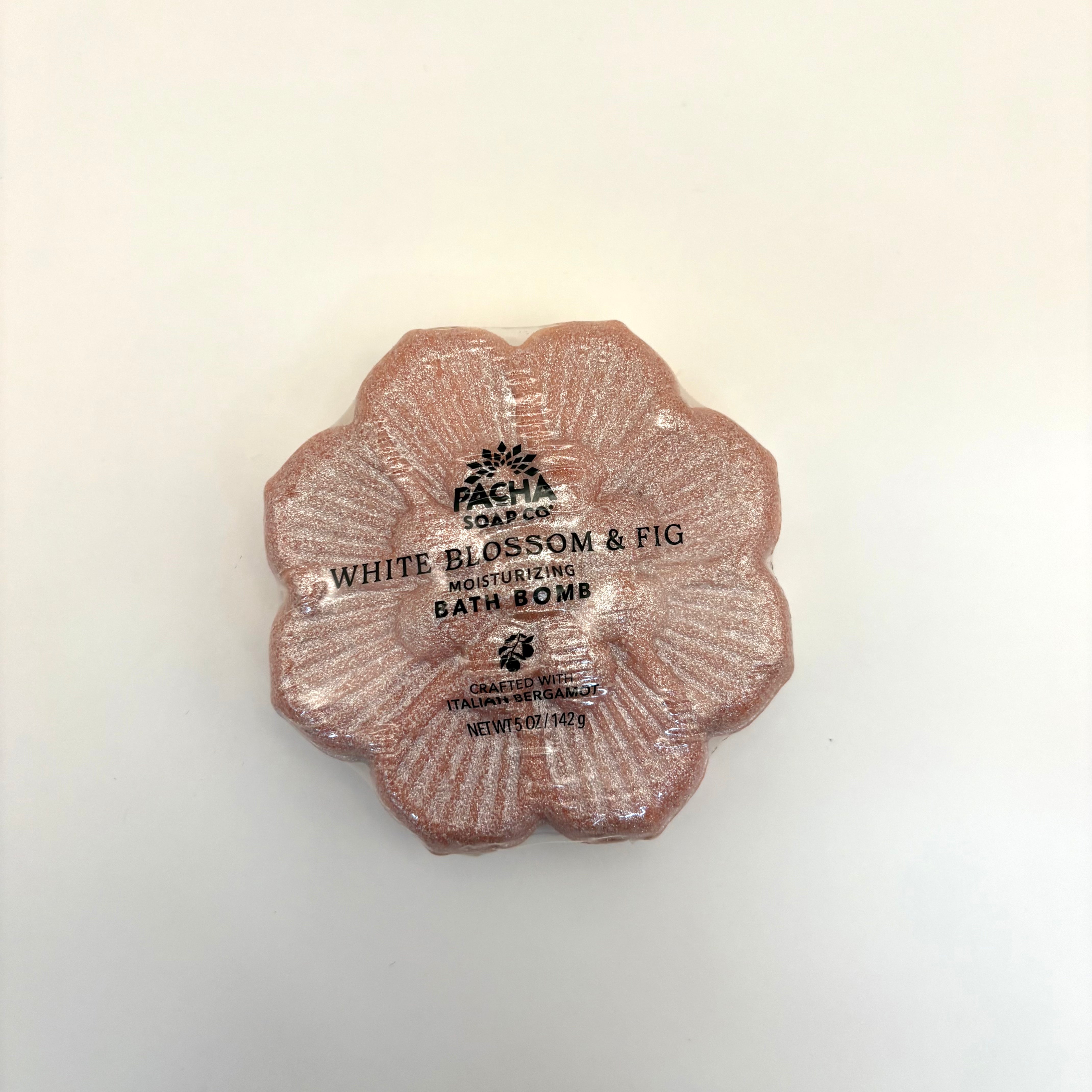 White blossom and fig bath bomb with 'Pacha Soap Co.' branding on a light background