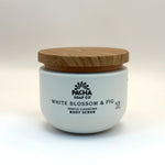 Pacha white blossom and fig body scrub container with wooden lid on a white background
