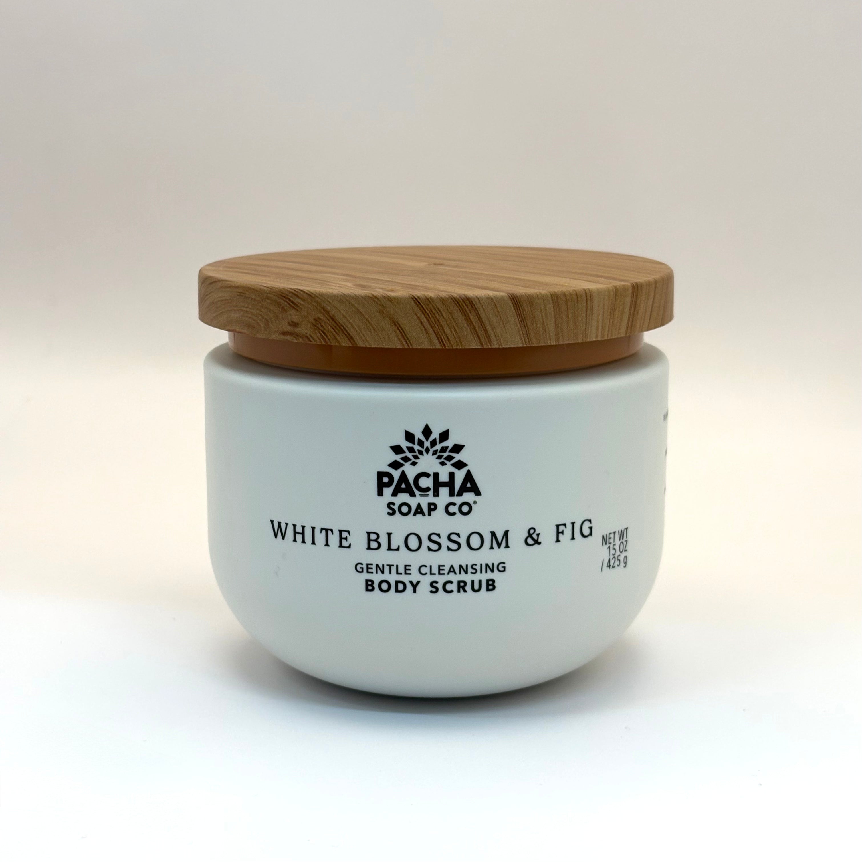 Pacha white blossom and fig body scrub container with wooden lid on a white background