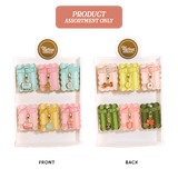 An assortment of six small zippered pouches or charms displayed on two white backing cards labeled FRONT and BACK, with a pink banner at the top reading PRODUCT ASSORTMENT ONLY. The items come in pastel and bright colors including pink, blue, yellow, green, and orange, each with a small gold-tone charm attached.