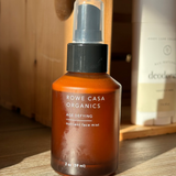 Brown bottle of Rowe Casa Organics face mist on a wooden surface