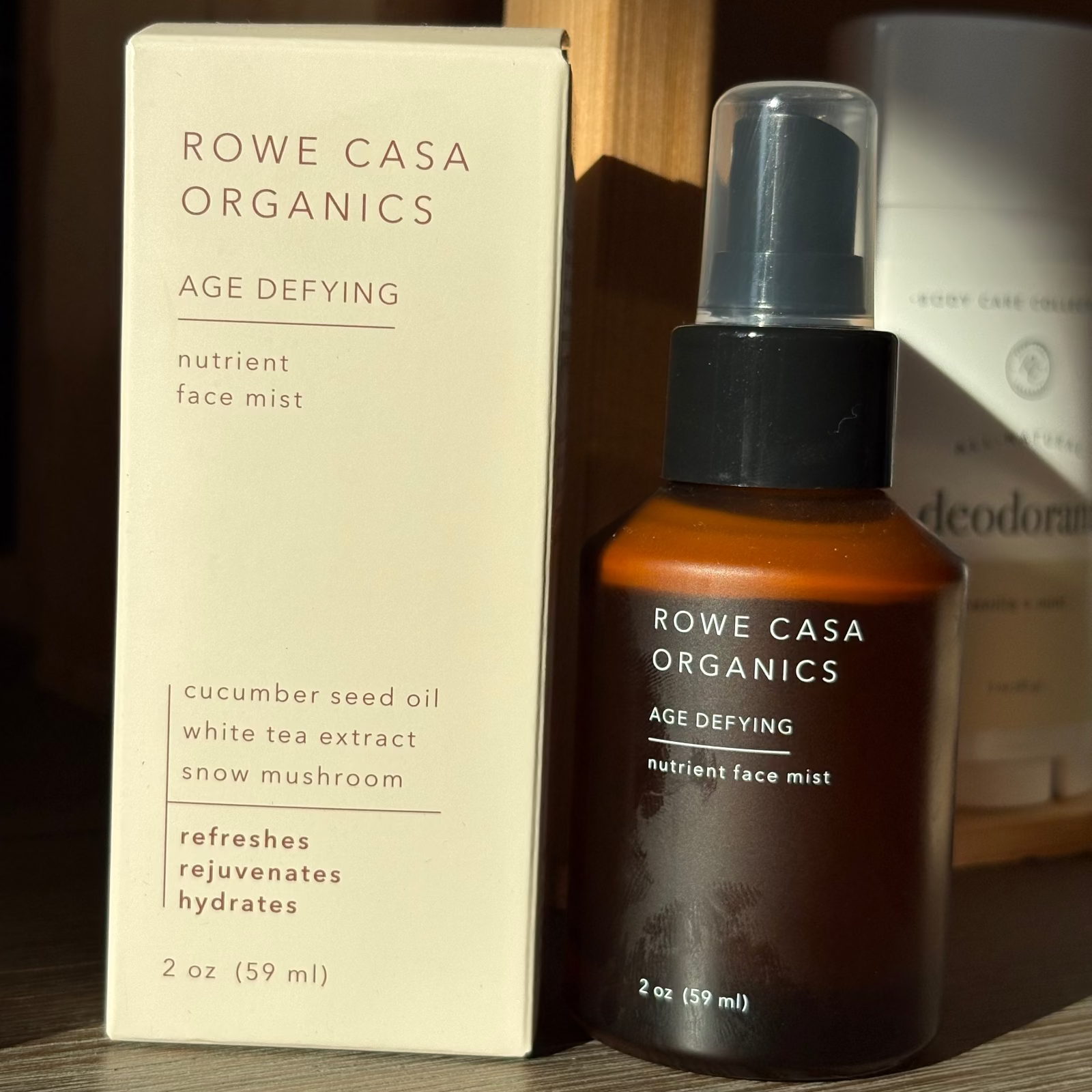 Rowe Casa Organics nutrient face mist bottle and packaging on a wooden surface