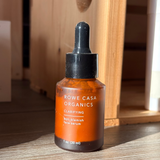 Bottle of Rowe Casa Organics serum on a wooden surface