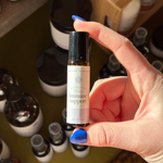 Hand holding a bottle labeled Rowe Casa immune Support in front of shelves with various other bottles.