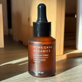 Rowe Casa Organics frankincense face oil bottle on a wooden surface