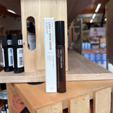 Rowe casa lash and brow serum with packaging on a wooden shelf in a store setting
