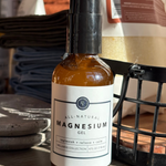 Bottle of All-Natural Magnesium Gel on a wooden surface with a blurred background