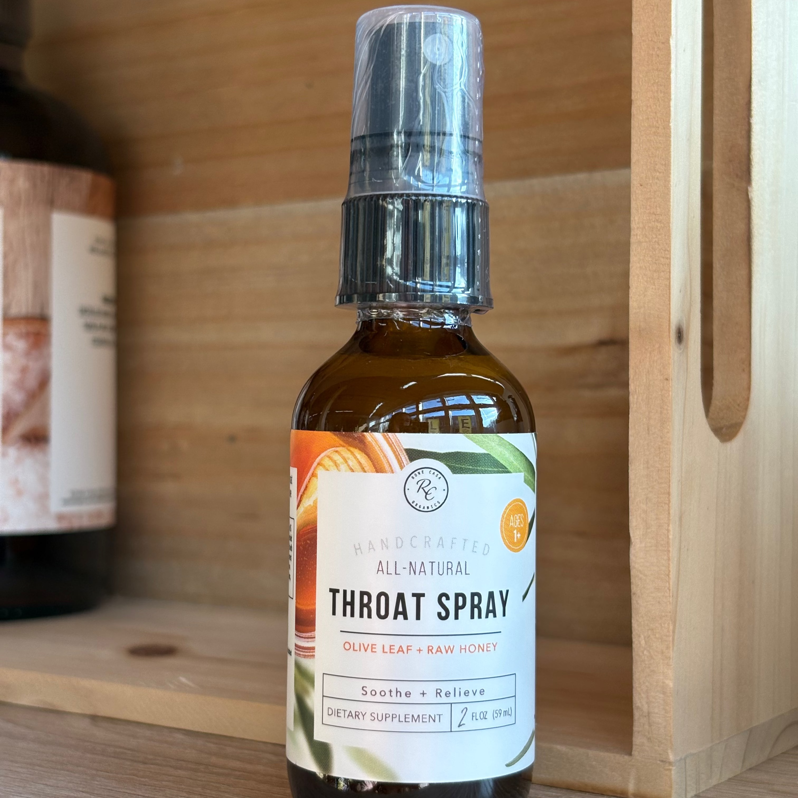 Bottle of all-natural throat spray on a wooden shelf