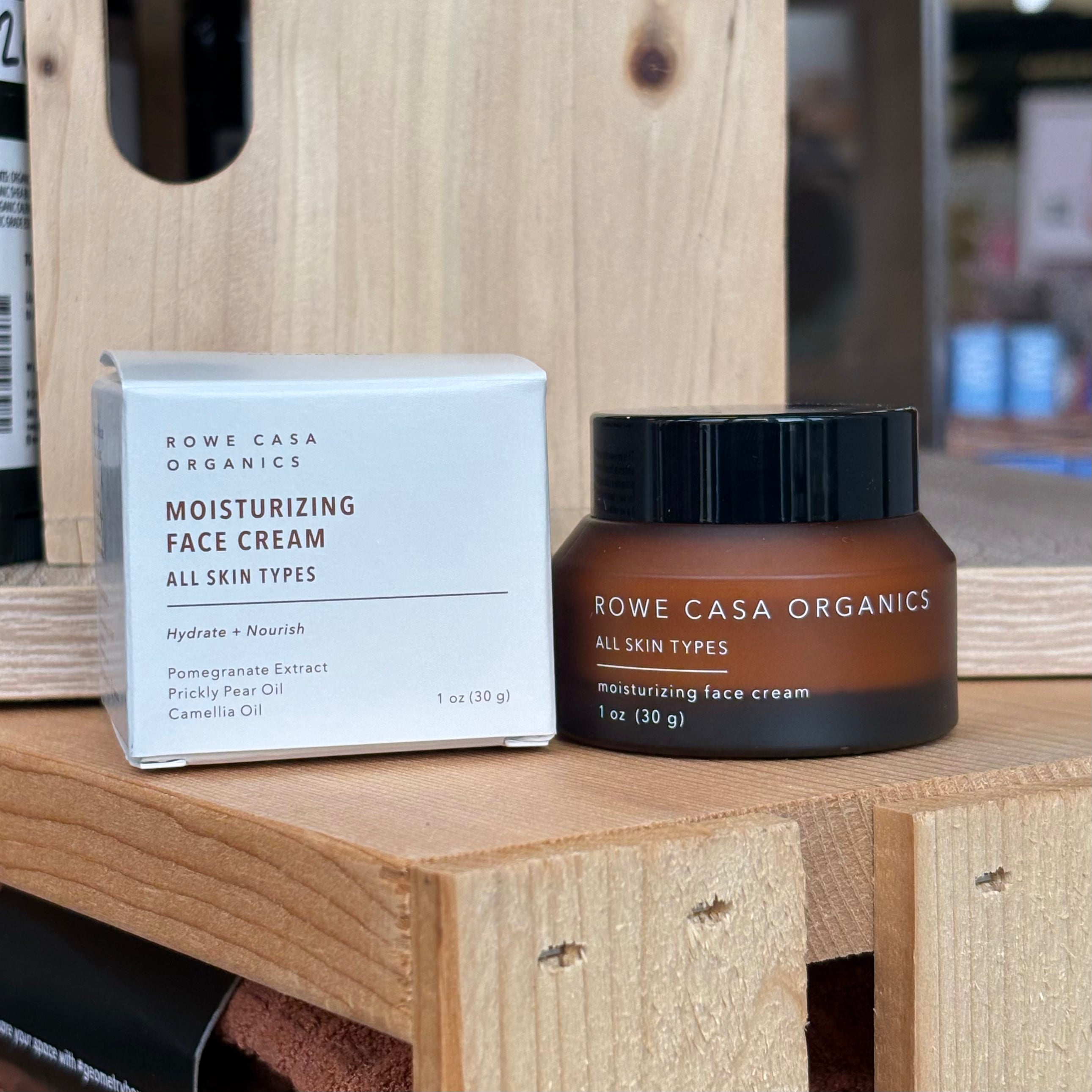 Rowe Casa Organics moisturizing face cream jar and box on a wooden surface